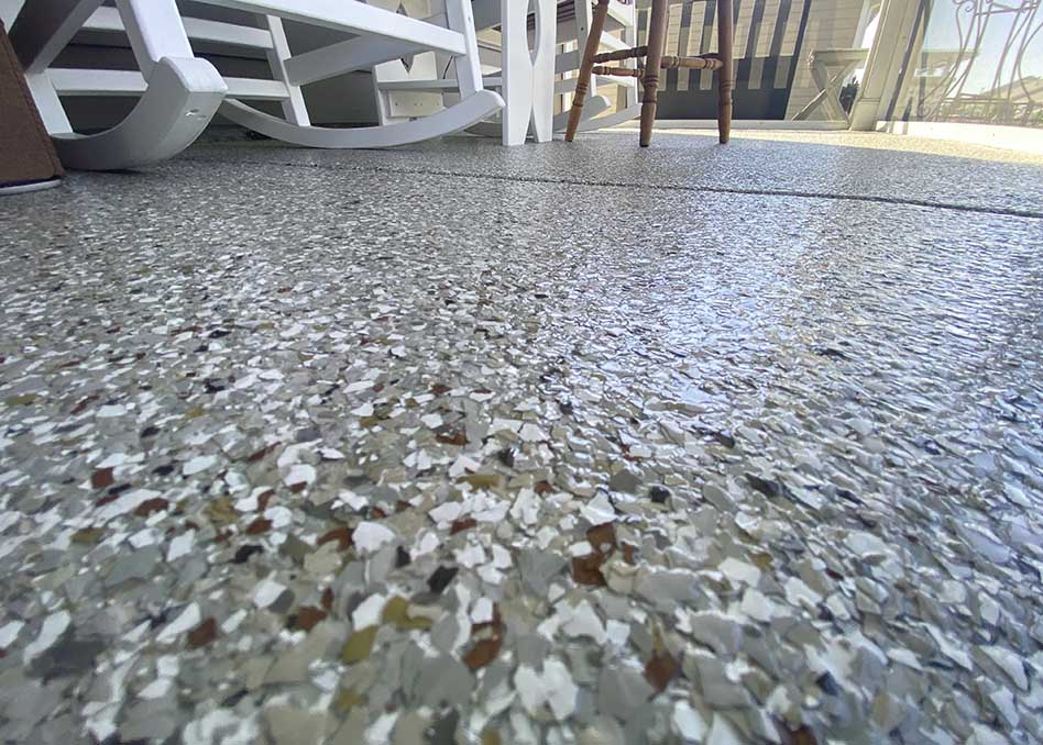 a white rocking chair and a stone floor on concrete coated floor