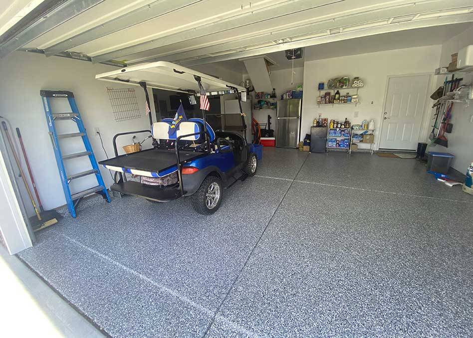 a golf cart in a garage on concrete coated floor