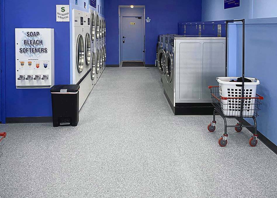 a laundry room with washing machines on concrete coated floor