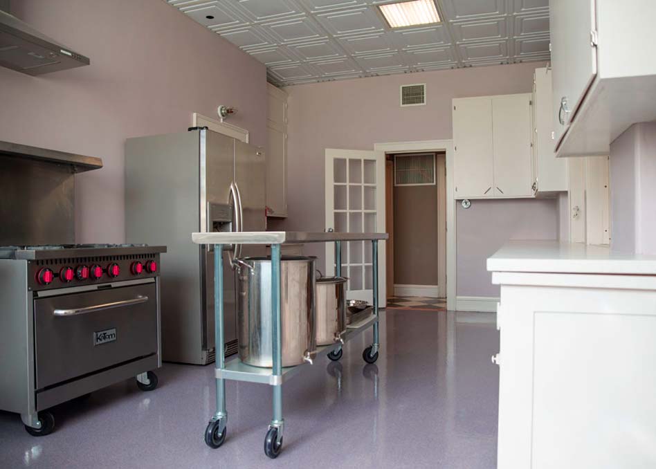 a kitchen with a large stainless steel cart on concrete coated floor